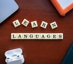Flat lay of language learning materials with gadgets promoting education.
