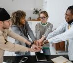 A diverse group of office co-workers sharing a team bonding moment.